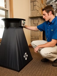 HVAC Expert testing air flow from a floor vent